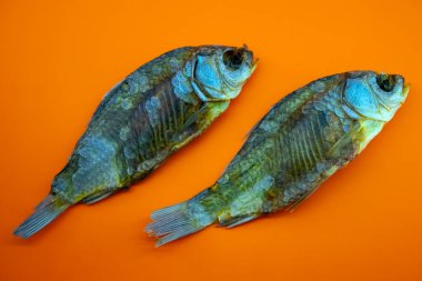 Turuncu arka planda kuru balık, yakın plan.