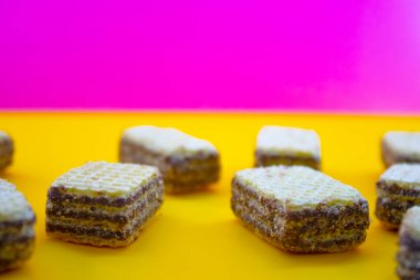 Pembe arka planda çikolatalı bulanık gofretler.