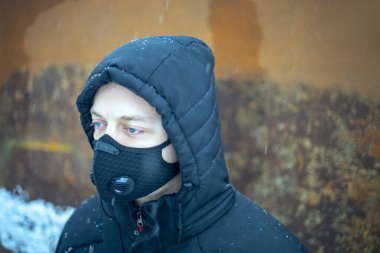 Şiddetli kar yağışı sırasında maske takan adam.