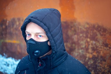 Şiddetli kar yağışı sırasında maske takan adam.