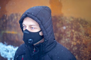 Şiddetli kar yağışı sırasında maske takan adam.