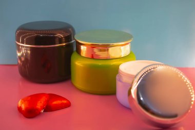 Pembe ve mavi arkaplanda farklı makyaj malzemeleri ve aksesuarları. Makyaj Moda Konsepti