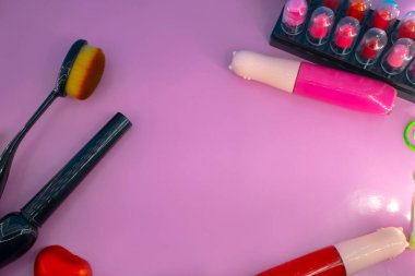 Pembe ve mavi arkaplanda farklı makyaj malzemeleri ve aksesuarları. Makyaj Moda Konsepti