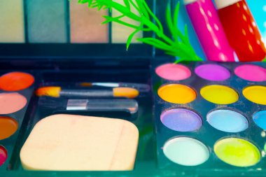 Pembe ve mavi arkaplanda farklı makyaj malzemeleri ve aksesuarları. Makyaj Moda Konsepti