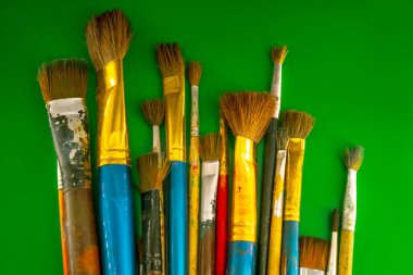 Yeşil arka planda boya için eski fırçalar