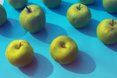 mavi arkaplanda yeşil elma, meyveler