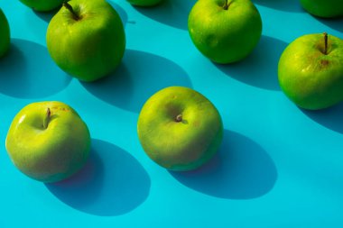 mavi arkaplanda yeşil elma, meyveler