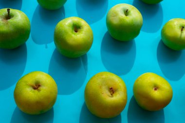 mavi arkaplanda yeşil elma, meyveler