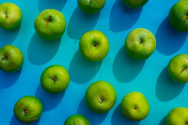 mavi arkaplanda yeşil elma, meyveler