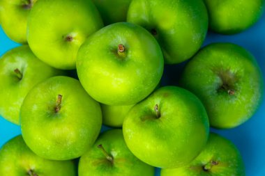 mavi arkaplanda yeşil elma, meyveler