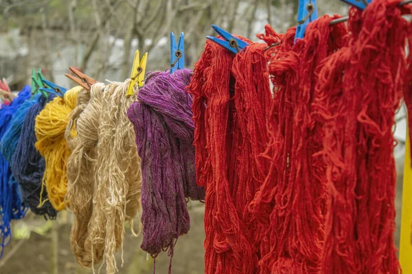 ウールのカラフルな糸は 屋外のクロッシンプと布にかかっています — ストック写真