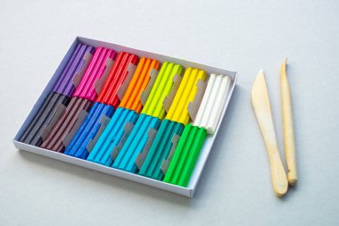 Beyaz arka planda izole edilmiş renkli plastik çubuklar. Çocuklar için gökkuşağı modelleme kil oyunu ve yaratıcılık.