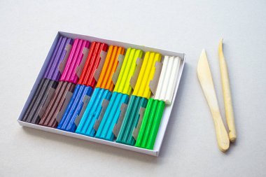 Beyaz arka planda izole edilmiş renkli plastik çubuklar. Çocuklar için gökkuşağı modelleme kil oyunu ve yaratıcılık.