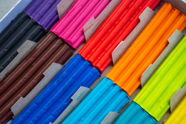 Beyaz arka planda izole edilmiş renkli plastik çubuklar. Çocuklar için gökkuşağı modelleme kil oyunu ve yaratıcılık.