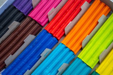 Beyaz arka planda izole edilmiş renkli plastik çubuklar. Çocuklar için gökkuşağı modelleme kil oyunu ve yaratıcılık.