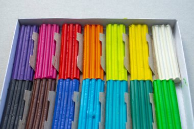 Beyaz arka planda izole edilmiş renkli plastik çubuklar. Çocuklar için gökkuşağı modelleme kil oyunu ve yaratıcılık.