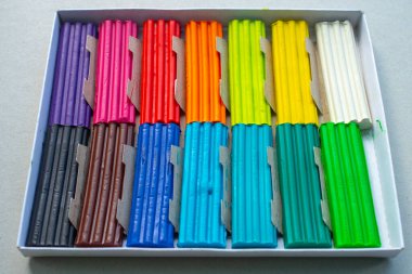 Beyaz arka planda izole edilmiş renkli plastik çubuklar. Çocuklar için gökkuşağı modelleme kil oyunu ve yaratıcılık.