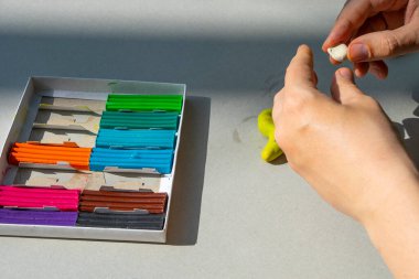 Masadaki plastik maddeden çocuk kalıpları. Çocuklar renkli plastik ellerle, çocuklar eğitici oyuncaklarla.