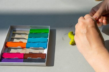 Masadaki plastik maddeden çocuk kalıpları. Çocuklar renkli plastik ellerle, çocuklar eğitici oyuncaklarla.