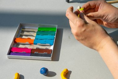 Masadaki plastik maddeden çocuk kalıpları. Çocuklar renkli plastik ellerle, çocuklar eğitici oyuncaklarla.