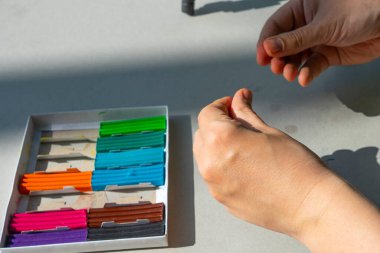 Masadaki plastik maddeden çocuk kalıpları. Çocuklar renkli plastik ellerle, çocuklar eğitici oyuncaklarla.