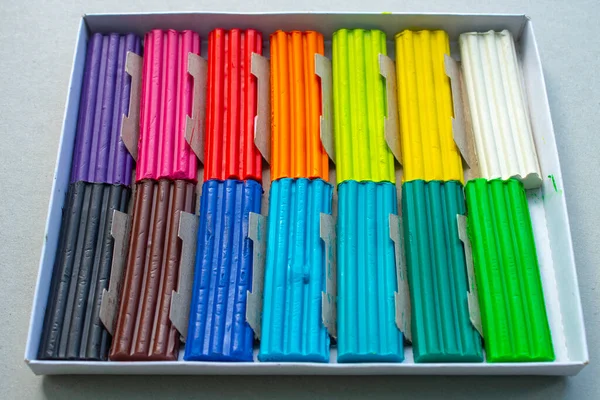 Beyaz arka planda izole edilmiş renkli plastik çubuklar. Çocuklar için gökkuşağı modelleme kil oyunu ve yaratıcılık.