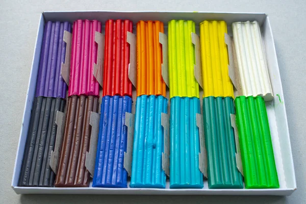 Beyaz arka planda izole edilmiş renkli plastik çubuklar. Çocuklar için gökkuşağı modelleme kil oyunu ve yaratıcılık.