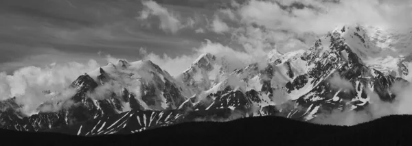 Black and white landscape. Snow-capped mountain peaks. Traveling in the mountains, climbing.