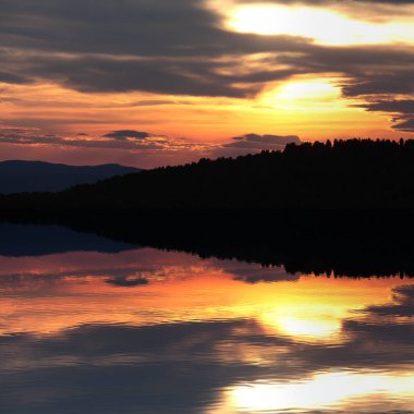 Gölde parlak bir günbatımının güzel yansıması