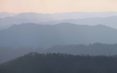 Gün batımında dağların siluetinin resimsel görüntüsü
