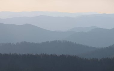 Gün batımında dağların siluetinin resimsel görüntüsü
