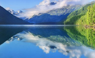 Dağ Gölü, güzel bir yansıma. Sabah ışığı, bulutların tepeleri. Resimli dağ manzarası. Altai, Sibirya 'da vahşi bir yer. Seyahat ve yaz tatili.