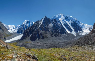 Mountain landscape, alpine relief. Glaciers, snow-capped peaks and steep rocky slopes.