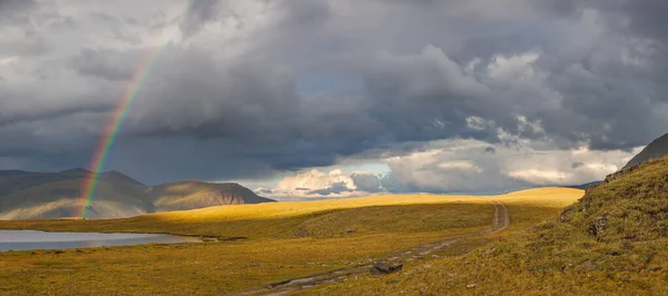 Rainbow in a mountain valley. Contrasting light.