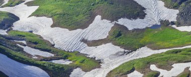 Güzel dağ vadisi, kar ve yeşiller yamaçlarda, panoramik görüntü