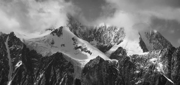 Black and white landscape. Snow-capped mountain peaks. Traveling in the mountains, climbing.