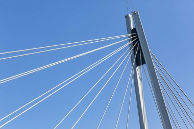 Yeni endüstriyel mühendislik tasarımı. Mavi gökyüzüne karşı dikey kirişe bağlı çelik destek kabloları.
