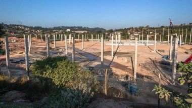 Yeni fabrika deposunun inşaatı, inşaat sahasının üzerine yeni dikey beton sütunlar döşemesi..