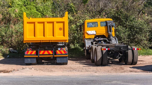 New trucks industrial vehicle with tipper bins painted bright yellow out the painting building factory  for contruction earthworks.