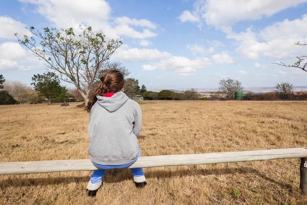 Девочка-подросток сидит на открытом воздухе — стоковое фото