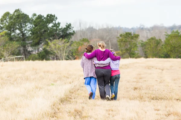 Madre Hijas caminando abrazándose al aire libre — Foto de Stock