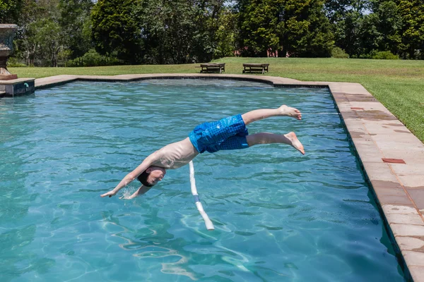 Ragazzo salto immersioni piscina estate — Foto Stock