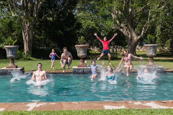 Chicas chicos saltando piscina —  Fotos de Stock