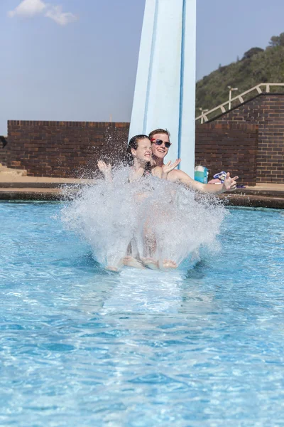 Adolescentes piscina diapositiva chapoteo vacaciones —  Fotos de Stock