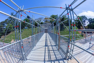 Köprü Çelik İskelesi, kırsal bölgedeki yeni köprü inşaatı sırasında karayolu üzerinden geçici yaya geçişi yapıyor..