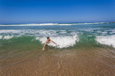Çocuk yüzerek kıyıya Break dalga