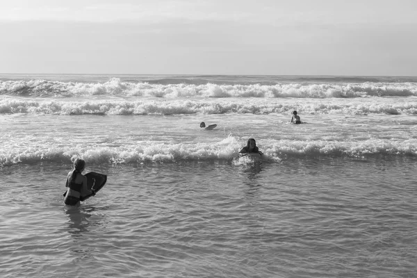 Teenagere svømme bestyrelser Ocean - Stock-foto