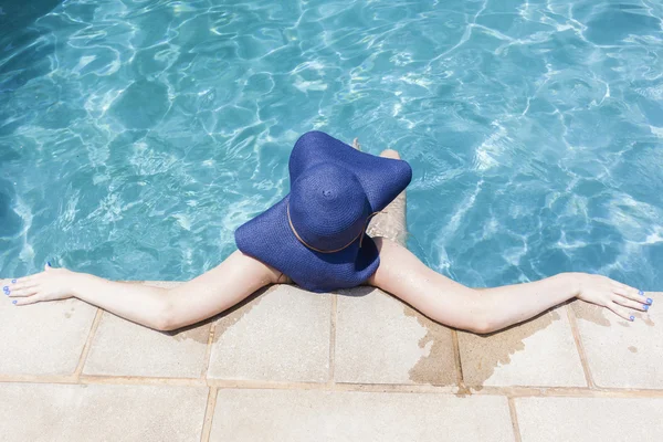 Fille chapeaux bleus mains piscine — Photo