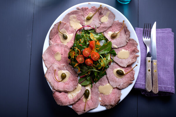 vitello tonnato on a serving plate with water