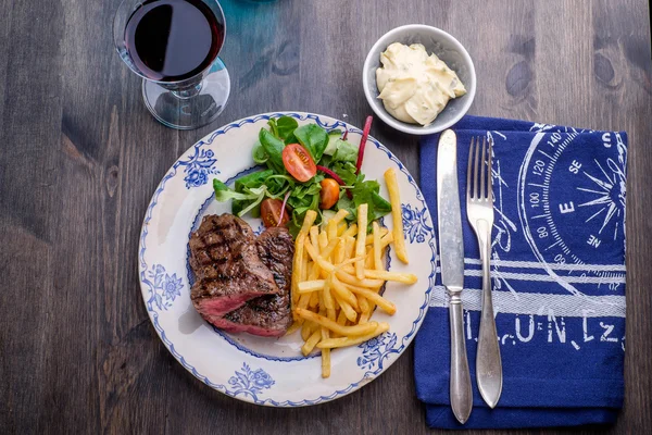 Steak dinner with fries and sauce on the side — Stock Photo, Image